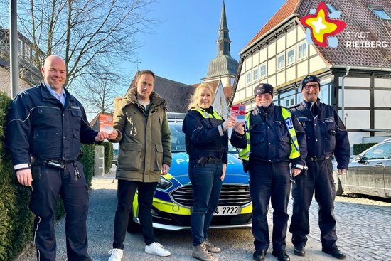 Kevin Reschke, Nils Kutscher, Vanessa Ogan und die Polizeihauptkommissare Heinrich Gutzler und Rainer Borgmeier stehen in Uniform nebeneinander und lächeln in die Kanmera.