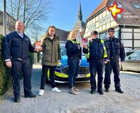 Kevin Reschke, Nils Kutscher, Vanessa Ogan und die Polizeihauptkommissare Heinrich Gutzler und Rainer Borgmeier stehen in Uniform nebeneinander und lächeln in die Kanmera.