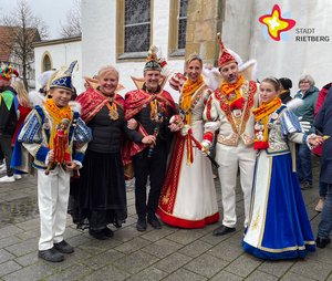 Drei Prinzenpaare stehen in vollem Kostüm nebeneinander vor der Pfarrkirche.