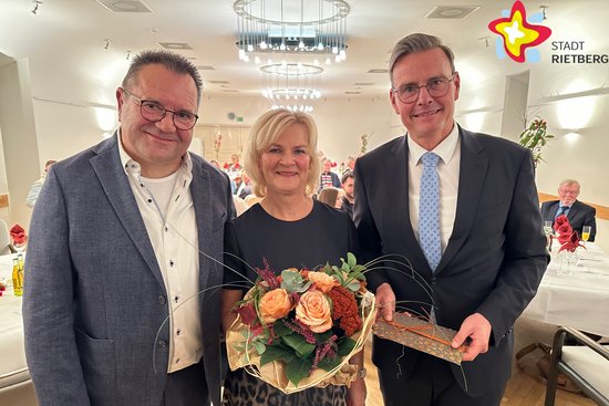 Der scheidende Beigeordnete Andreas Göke mit seiner Frau Ulla und Bürgermeister Andreas Sunder (von links) stehen im Ratssaal. Ulla Göke hält einen Blumenstrauß in den Händen.