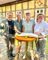 Bürgermeister Andreas Sunder, Bernd Hanhardt, Martin Lück und Klaus Feldmann stehen nebeneinander hinter einem runden Stehtisch, auf dem das Goldene Buch der Stadt aufgeschlagen liegt.