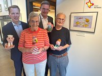 Künstler Johan Sol, seine Ehefrau Cobi, Bürgermeister Andreas Sunder und Kay Klingsiek, Vorsitzender der Stiftung der Sparkasse Rietberg, vor einem Werk des Künstlers mit Figuren aus der Ausstellung in der Hand.