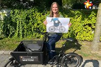 Mobilitätsmanagerin Silke Hildebrandt mit Bild des Maskottchens der Europäischen Mobilitätswoche und Fahrrad.