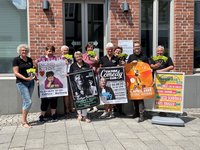 Mitglieder des Vereins Kulturig mit Plakaten für die neue Spielzeit vor der Touristikinformation.