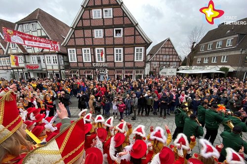 Das Foto zeigt einen Blick auf die Rathausstraße. Karnevalisten in Gardeuniformen feiern gemeinsam mit Besuchern.